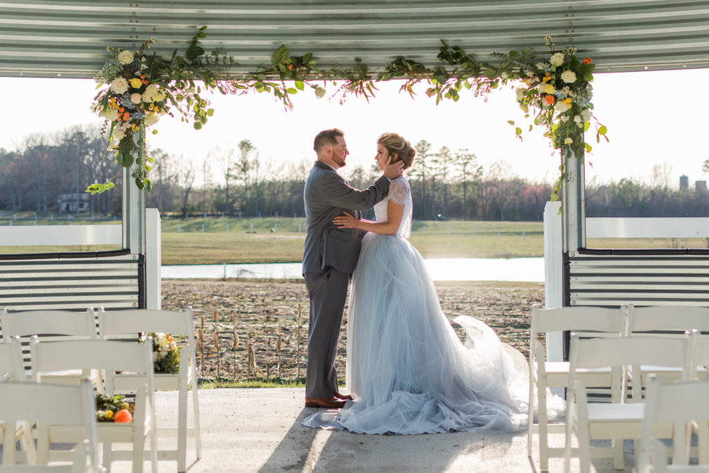 A couple under floral decorations in the grain-bin gazebo
