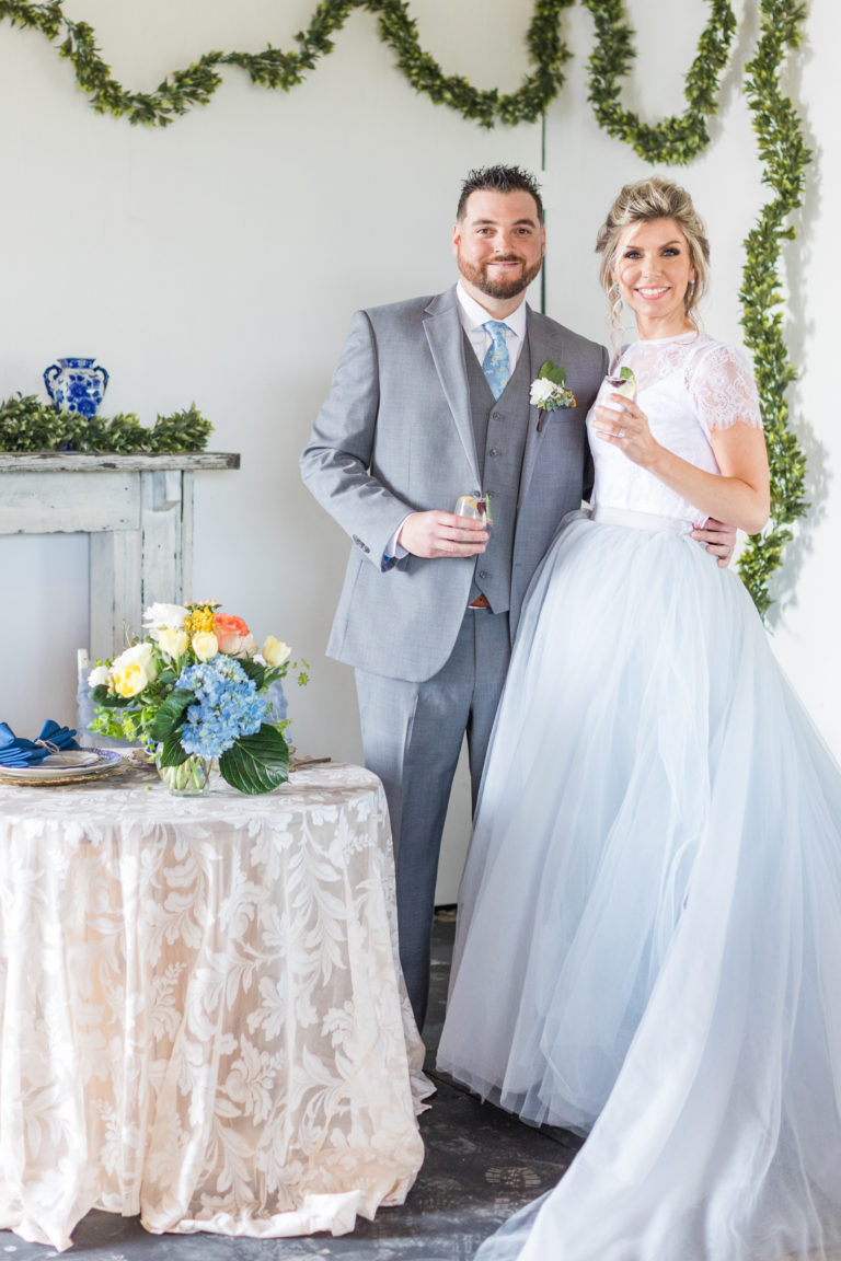 A couple standing beside a flower arrangement